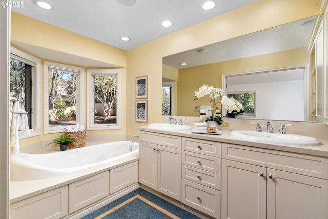 bathroom with plenty of natural light, a tub, and vanity