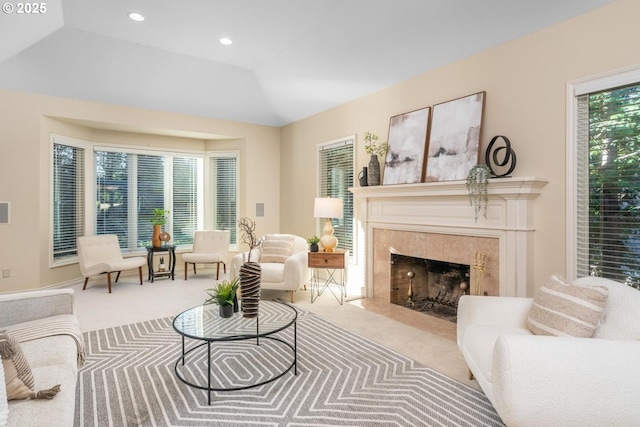 interior space featuring vaulted ceiling, a healthy amount of sunlight, carpet floors, and a tiled fireplace