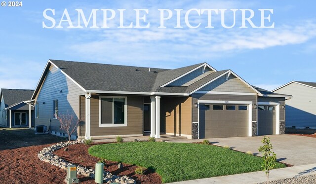 view of front of home featuring a garage and central air condition unit