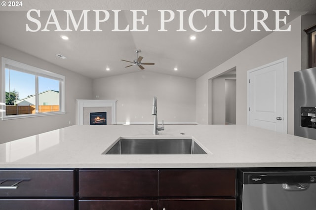 kitchen featuring appliances with stainless steel finishes, dark brown cabinets, vaulted ceiling, sink, and ceiling fan