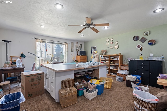 carpeted office space with ceiling fan and a textured ceiling