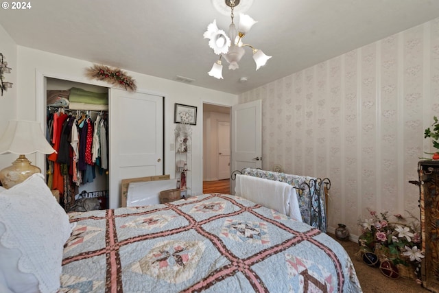 bedroom with an inviting chandelier, carpet floors, and a closet