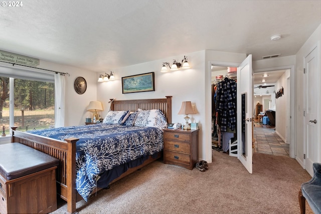 carpeted bedroom with a walk in closet, a closet, and a textured ceiling