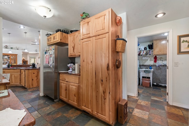 kitchen featuring pendant lighting, stainless steel fridge, and light brown cabinets