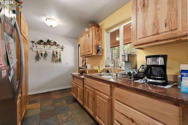 kitchen featuring sink, stainless steel fridge, and light brown cabinetry