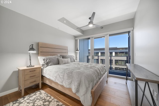 bedroom with access to exterior, light wood-type flooring, and ceiling fan