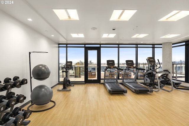 workout area featuring wood-type flooring and a wall of windows