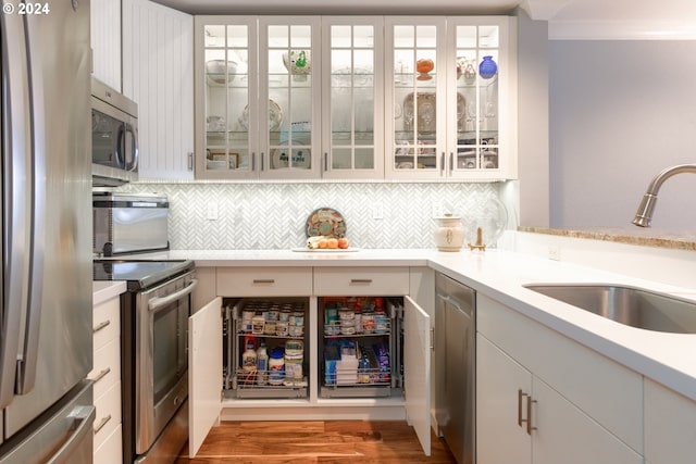 kitchen featuring sink, white cabinetry, stainless steel appliances, and ornamental molding