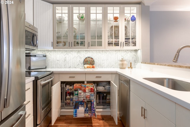 kitchen featuring white cabinets, stainless steel appliances, crown molding, and sink