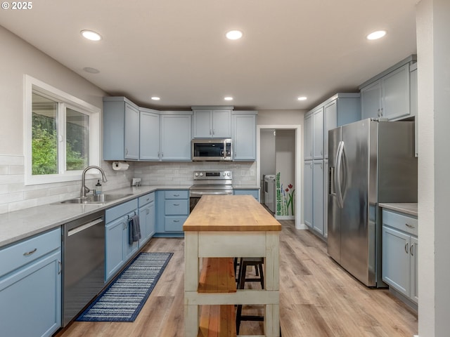 15836 SW Division St, Sherwood, OR 97140 - kitchen featuring stainless steel appliances, a sink, wooden counters, tasteful backsplash, and recessed lighting