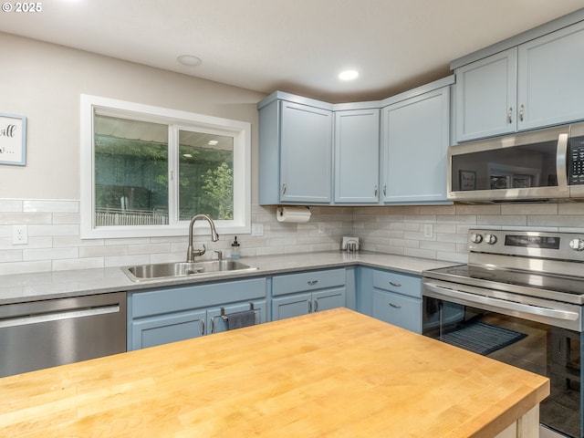 15836 SW Division St, Sherwood, OR 97140 - kitchen with appliances with stainless steel finishes, a sink, butcher block countertops, decorative backsplash, and recessed lighting