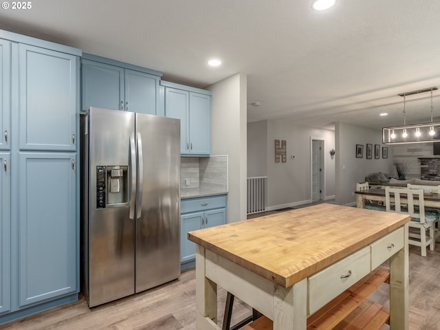 15836 SW Division St, Sherwood, OR 97140 - kitchen with stainless steel refrigerator with ice dispenser, blue cabinets, wood counters, decorative backsplash, and recessed lighting
