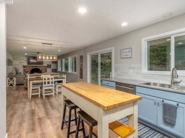 15836 SW Division St, Sherwood, OR 97140 - kitchen with wooden counters, a sink, stainless steel dishwasher, open floor plan, and decorative backsplash