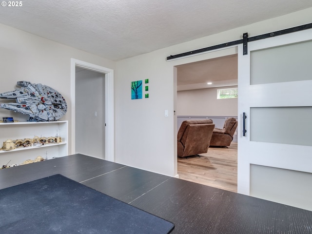 15836 SW Division St, Sherwood, OR 97140 - interior space with a barn door, wood finished floors, and a textured ceiling