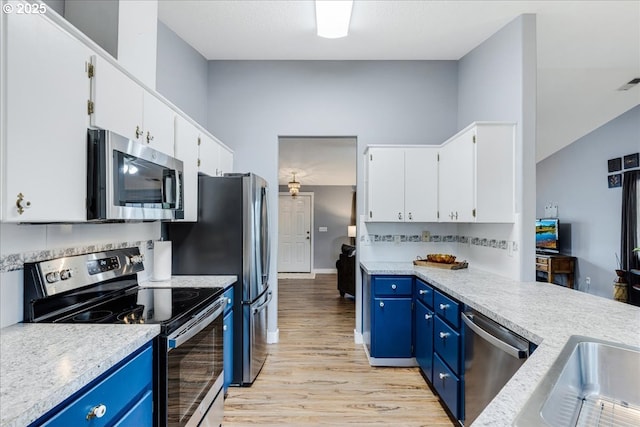 kitchen featuring blue cabinetry, light wood-type flooring, white cabinetry, and stainless steel appliances