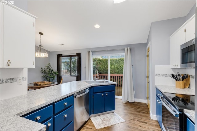 kitchen with pendant lighting, blue cabinets, sink, white cabinetry, and stainless steel appliances