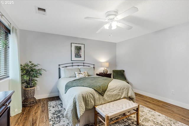 bedroom featuring multiple windows, ceiling fan, a textured ceiling, and hardwood / wood-style flooring