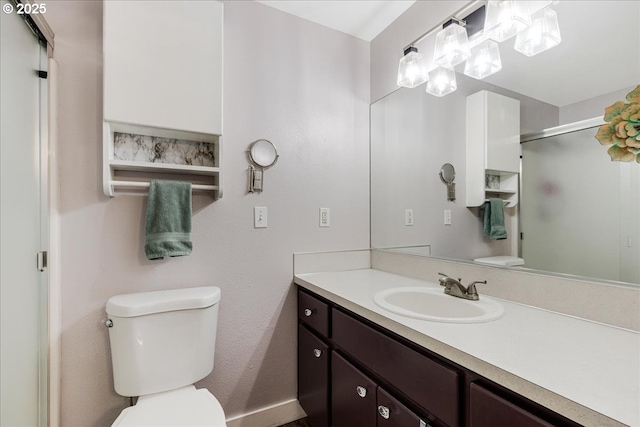 bathroom featuring vanity, an enclosed shower, and toilet