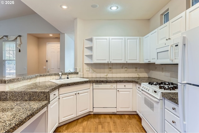 kitchen featuring decorative backsplash, kitchen peninsula, white appliances, sink, and white cabinets