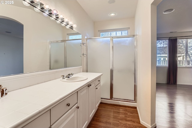 bathroom featuring hardwood / wood-style flooring, vanity, an enclosed shower, and a wealth of natural light