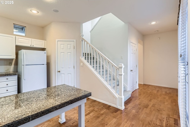 kitchen with white refrigerator, light wood-type flooring, and white cabinetry