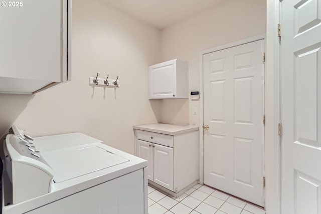 clothes washing area with cabinets, light tile patterned floors, and washing machine and dryer