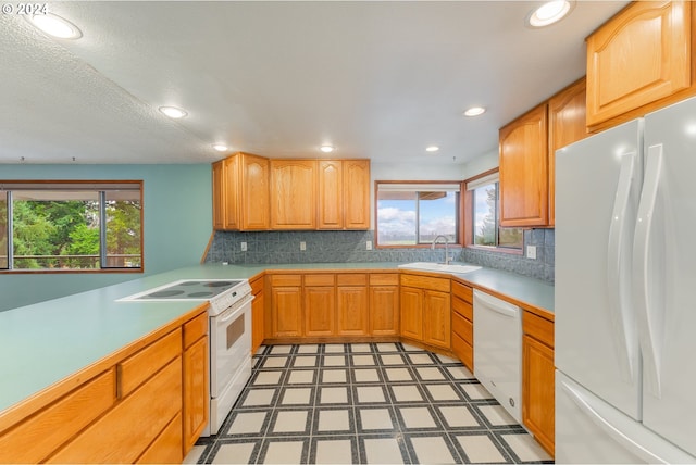 kitchen with decorative backsplash, white appliances, sink, and a wealth of natural light