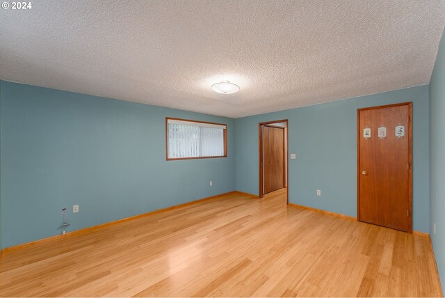 386 Longview Dr, Elkton, OR 97436 - spare room featuring wood finished floors, a textured ceiling, and baseboards