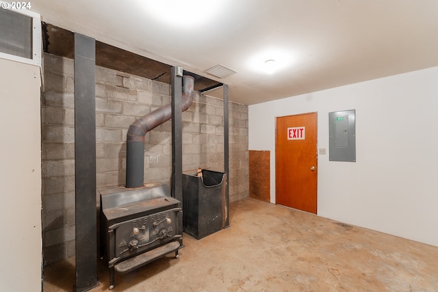 386 Longview Dr, Elkton, OR 97436 - below grade area featuring a wood stove, electric panel, and concrete block wall