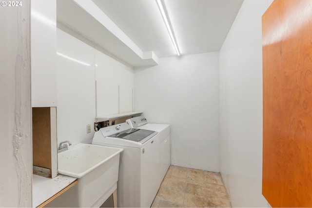 clothes washing area featuring sink and washer and dryer