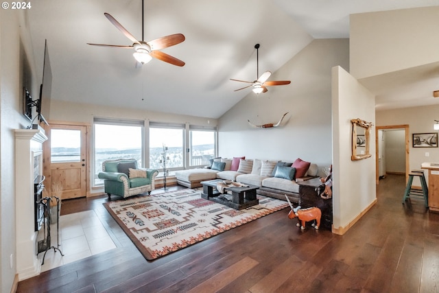 living room with a fireplace, high vaulted ceiling, ceiling fan, and dark wood-type flooring