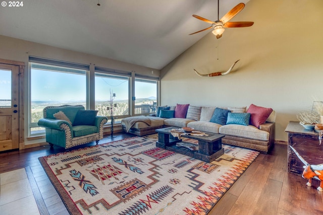 living room featuring ceiling fan, dark wood-type flooring, high vaulted ceiling, and a healthy amount of sunlight