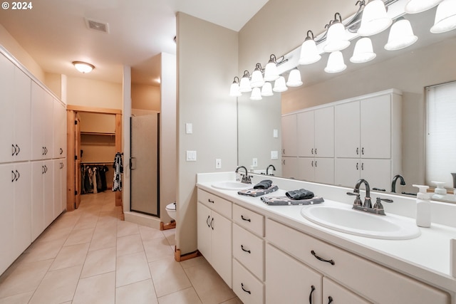 bathroom with toilet, vanity, tile patterned floors, and walk in shower