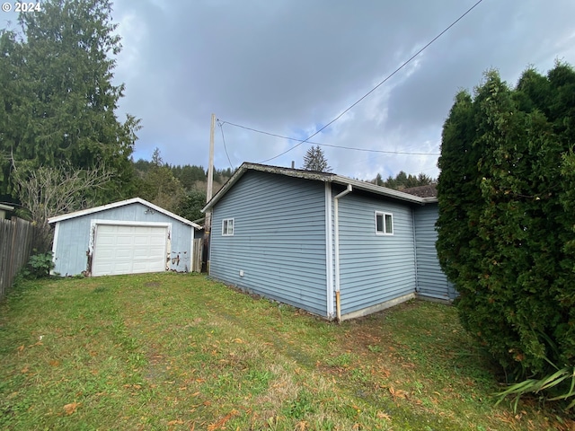 exterior space with a garage, an outdoor structure, and a yard