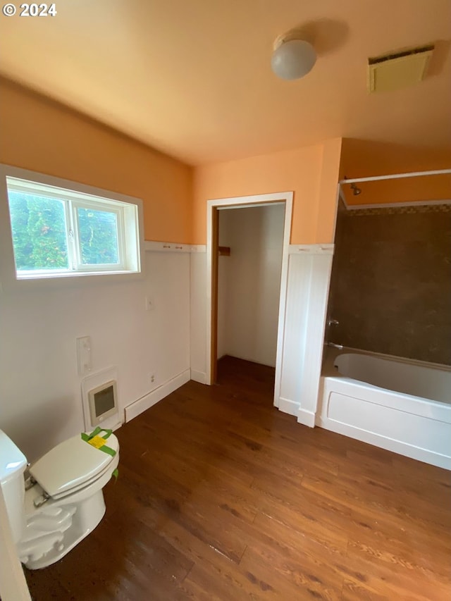 bathroom featuring toilet, shower / bath combination, heating unit, and hardwood / wood-style floors