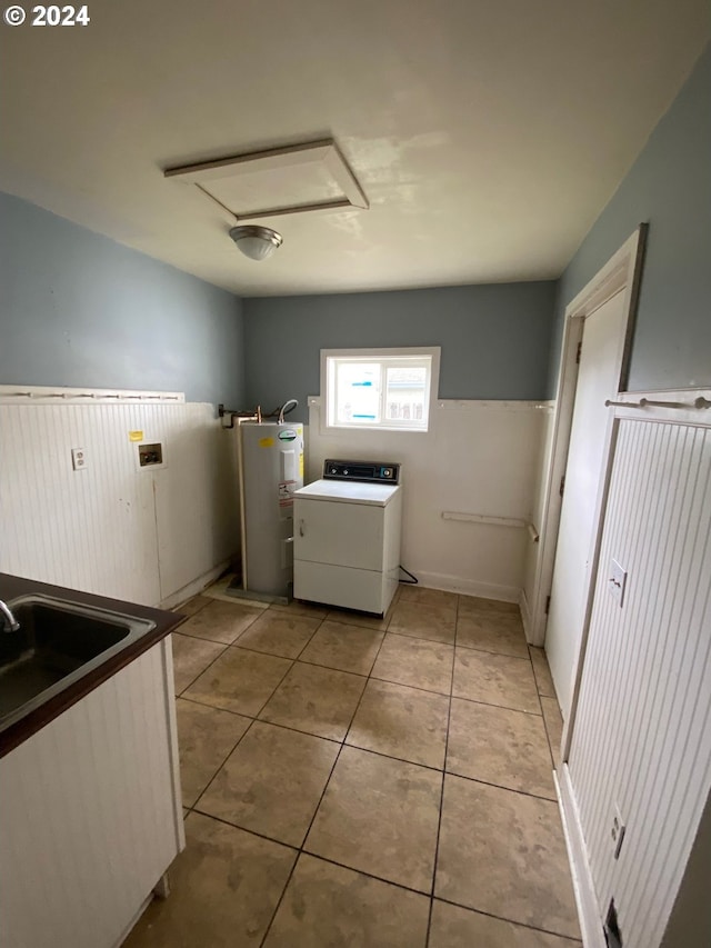 clothes washing area with sink, water heater, light tile patterned floors, and washer / clothes dryer