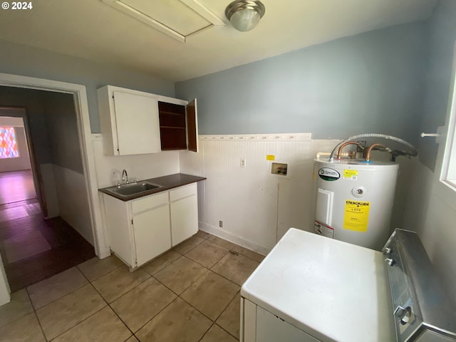 kitchen with white cabinets, water heater, sink, light tile patterned floors, and white fridge