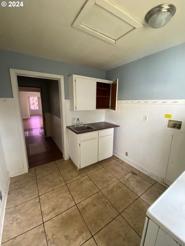 kitchen with white cabinetry, sink, and light tile patterned floors