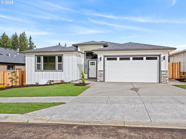 2891 NE Currin Creek Dr, Estacada, OR 97023 - prairie-style home featuring board and batten siding, fence, a garage, concrete driveway, and a front lawn