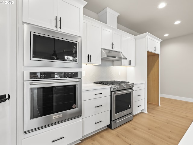 2891 NE Currin Creek Dr, Estacada, OR 97023 - kitchen with light wood finished floors, under cabinet range hood, light countertops, appliances with stainless steel finishes, and recessed lighting