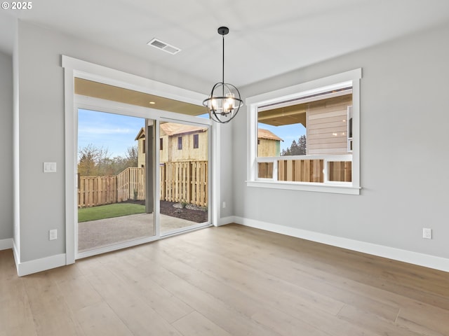 2891 NE Currin Creek Dr, Estacada, OR 97023 - unfurnished dining area with an inviting chandelier, wood finished floors, visible vents, and baseboards