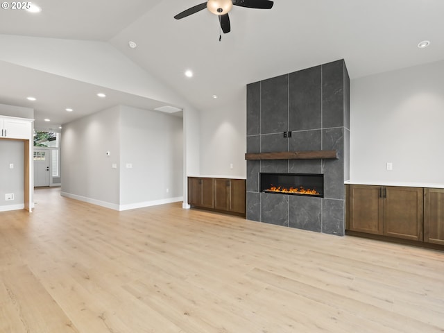 2891 NE Currin Creek Dr, Estacada, OR 97023 - unfurnished living room with light wood-style flooring, a fireplace, ceiling fan, vaulted ceiling, and recessed lighting