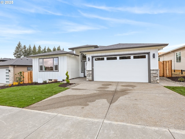 2891 NE Currin Creek Dr, Estacada, OR 97023 - prairie-style house featuring board and batten siding, fence, an attached garage, concrete driveway, and a front lawn