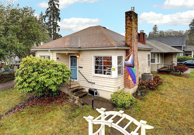 back of property with central air condition unit and a lawn