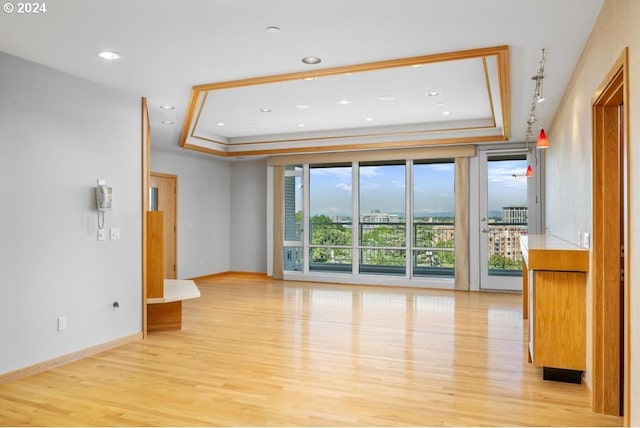 interior space with light hardwood / wood-style flooring and a tray ceiling