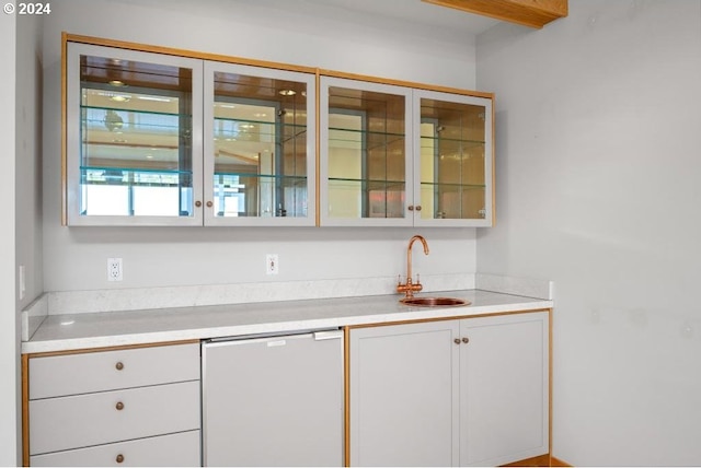 bar with dishwashing machine, sink, and white cabinets