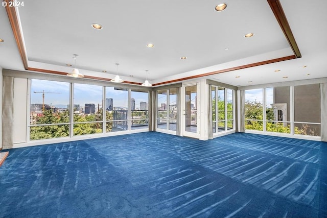 interior space with dark colored carpet and a tray ceiling