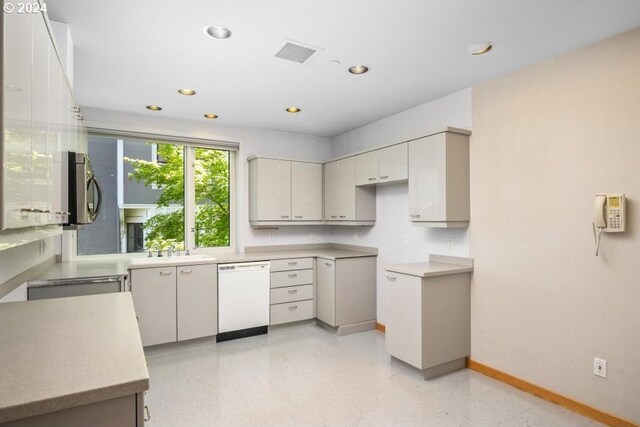 kitchen featuring white dishwasher and gray cabinets