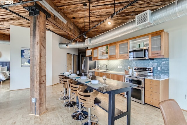 kitchen featuring tasteful backsplash, decorative light fixtures, appliances with stainless steel finishes, and sink