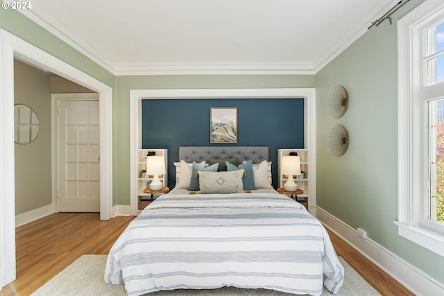 bedroom featuring ornamental molding and light wood-type flooring